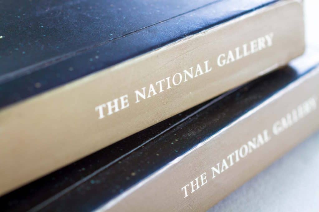 Close up on the National Gallery logo on the spine of the Rebels and Martyrs exhibition catalogue.