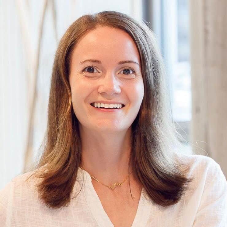 Stefanie Kruse, a white-presenting woman with long, light brown hair, smiling while looking at the camera